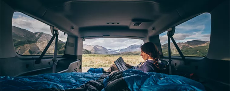 young woman reading in van